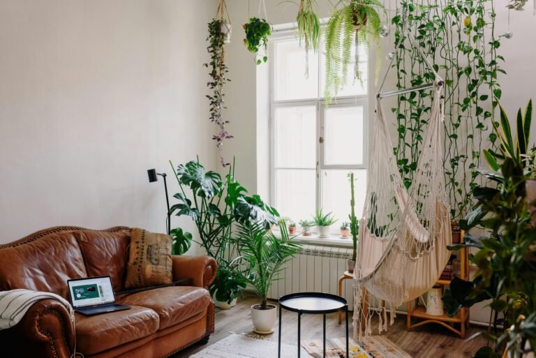 Modern living room with lush indoor plants, hammock, and sofa for a serene atmosphere.